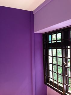 a room with purple walls and black windows