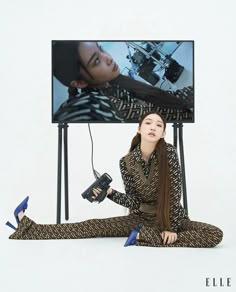 a woman is sitting on the floor in front of a television