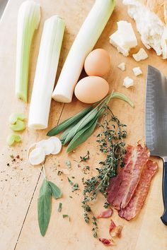 an assortment of food on a cutting board with a knife and other ingredients next to it