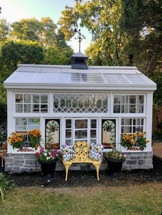 a small white house with flowers in the windows