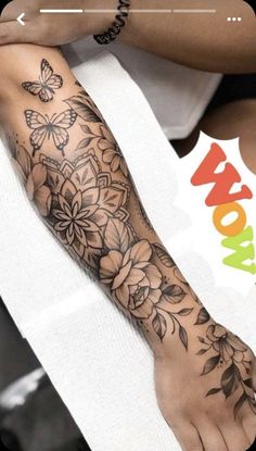 a woman's arm with flowers and butterflies on it