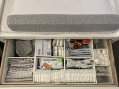 an open drawer with diapers and other items in it