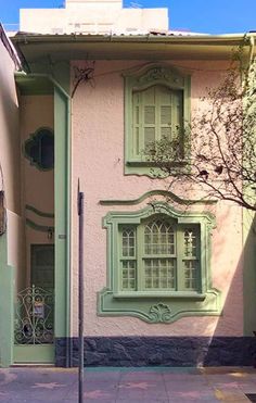 an old pink and green building with windows