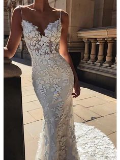 a woman in a white wedding dress standing outside