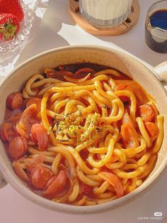 a bowl filled with pasta and tomatoes on top of a table