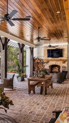 an outdoor living room with brick flooring and ceiling fans