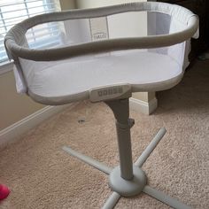 a baby crib sitting on top of a carpeted floor next to a window