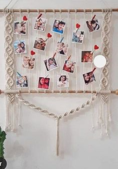 a macrame with pictures and hearts hanging on the wall next to a potted plant