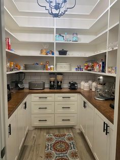 a kitchen with white cabinets and wooden floors