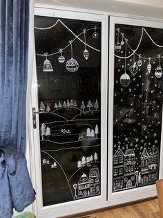 two windows with christmas decorations drawn on them