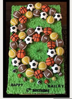 a birthday cake decorated with sports balls and footballs on it's number six