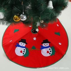 a christmas tree skirt with a snowman on it and ornaments hanging from the top