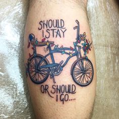 a man with a bike tattoo on his leg saying, should i stay or should i go?