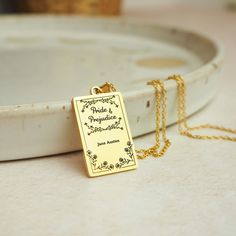 a gold plated necklace with the words bride and groom engraved on it sitting on a white tray