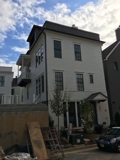 a large white house sitting on the side of a road next to a building with lots of windows