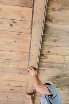 a man standing on top of a wooden floor next to a whiteboard board wall