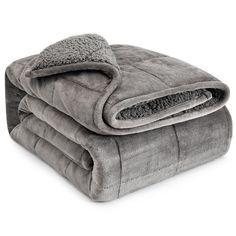 two blankets are folded on top of each other, one is grey and the other is gray