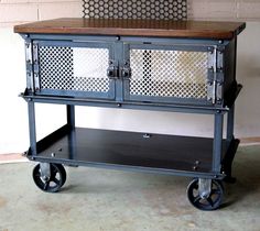 a metal cabinet with two doors and wheels on the bottom, sitting in front of a brick wall