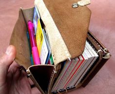 a person is holding a wallet full of books