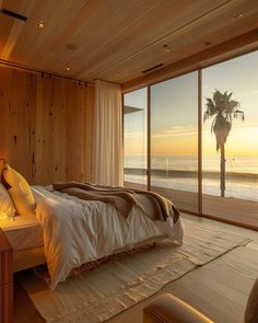 a bedroom with a large window overlooking the ocean and palm trees in front of it