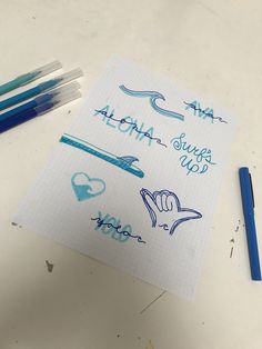 some blue markers are on top of a piece of paper with writing and pencils next to it