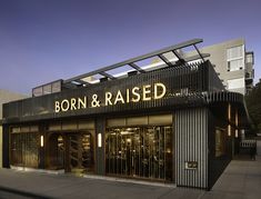 a store front with the words born and raised lit up