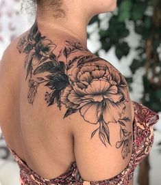 the back of a woman's shoulder with flowers on it