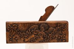 a wooden box with an ornate carving on the front and sides, holding a pair of scissors