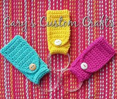 three crocheted purses sitting on top of a pink and yellow table cloth