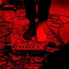 a person standing on top of a red carpet next to some wires and other electronic equipment