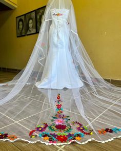 a white veil on top of a wedding dress in a room with wooden flooring