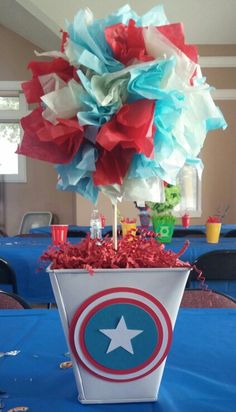 a captain america themed centerpiece on a table in a room with blue tables and chairs