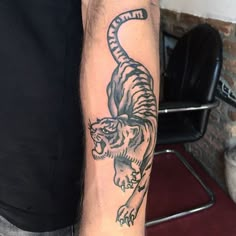 a man with a tiger tattoo on his arm