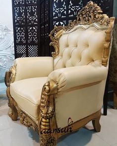 an ornately decorated chair sits in front of a wall