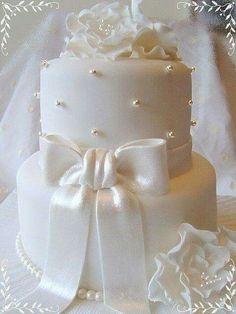 a wedding cake decorated with white flowers and pearls