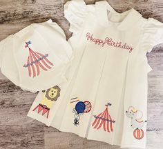 🎪This beautiful dress is perfect for Circus birthday or everyday wear.  It will have Happy Birthday or NAME/Initials at the top, 4 Circus theme designs; one on each pleat. The matching bloomers complete the entire look (please see option to purchase those). There is a listing for a boy outfit.  🎪The quality of this dress is amazing, it is made out of cotton pique, and can become an heirloom to pass to future generations!  🎪Customize this piece by adding monogram, initials, design or your chil Circus Embroidery Designs, Playful White Embroidered Dress, White Short Sleeve Birthday Dress, Short Sleeve Cotton Birthday Dress, Cotton Short Sleeve Birthday Dress, Fun Cotton Birthday Dress, Fun Ruffle Dress For Birthday, Playful Ruffle Dress For Birthday, Fun Cotton Dress For Birthday