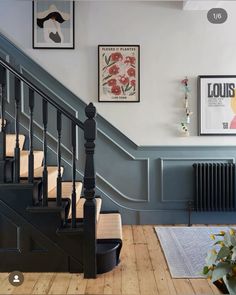 the stairs in this house are painted blue and have pictures hanging on the wall above them