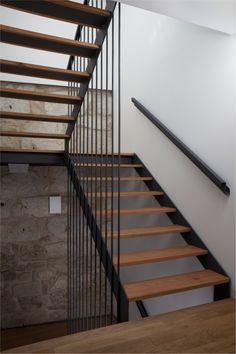 a wooden and metal stair case next to a brick wall