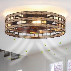 a ceiling light that is made out of wood planks and has green leaves on it