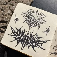 a notebook with black ink on it sitting on the ground next to a piece of paper