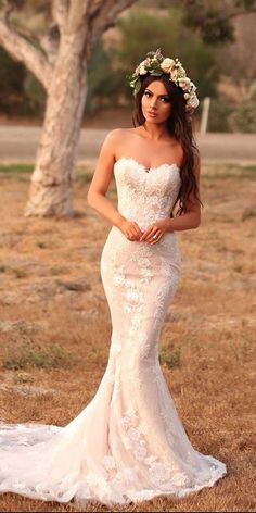 a woman in a wedding dress posing for the camera with her hand on her hip