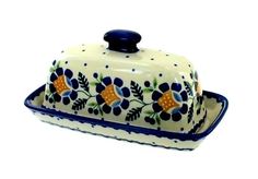 a blue and white ceramic covered dish with flowers on the front, sitting on a white surface