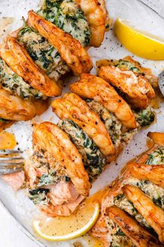 grilled shrimp with spinach and lemon on a platter next to a fork