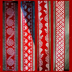 three different red and white ribbons with paisley designs on them, all lined up in rows