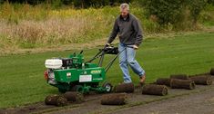 a man using a lawn mower to cut grass