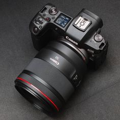 two cameras sitting next to each other on top of a black surface with one camera attached