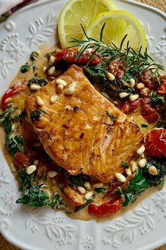 a white plate topped with fish and vegetables