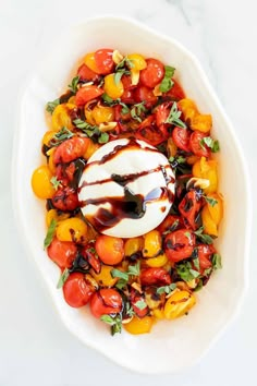 a white bowl filled with lots of colorful vegetables