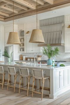 a large kitchen with white cabinets and wooden beams on the ceiling is decorated with wicker pendants