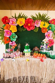 a table topped with lots of cake and cupcakes